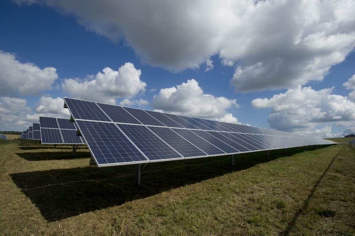 Rows of solar panels under partial cloud cover, demonstrating power generation in daylight not just sunshine